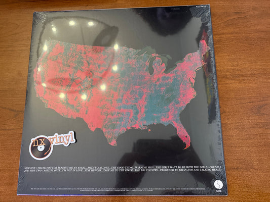 Vinyl record with a map of the United States on the cover, placed on a wooden surface.