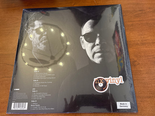 Vinyl record sleeve with a person's face and 'nx vinyl' branding on a wooden surface