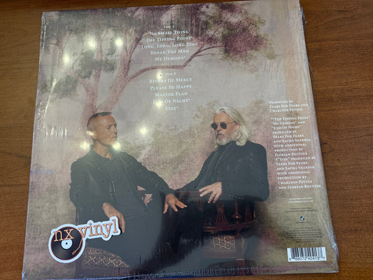 Vinyl record cover with two people sitting and text on a wooden surface
