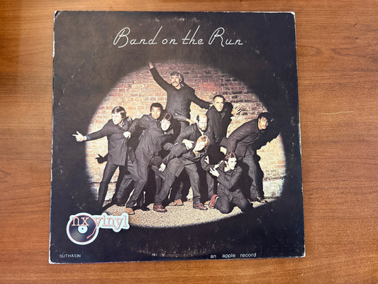 Vinyl record cover titled 'Band on the Run' with a group of people against a brick wall.