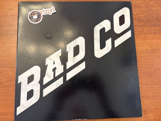 Vinyl record cover with 'Bad Company' text on a wooden surface
