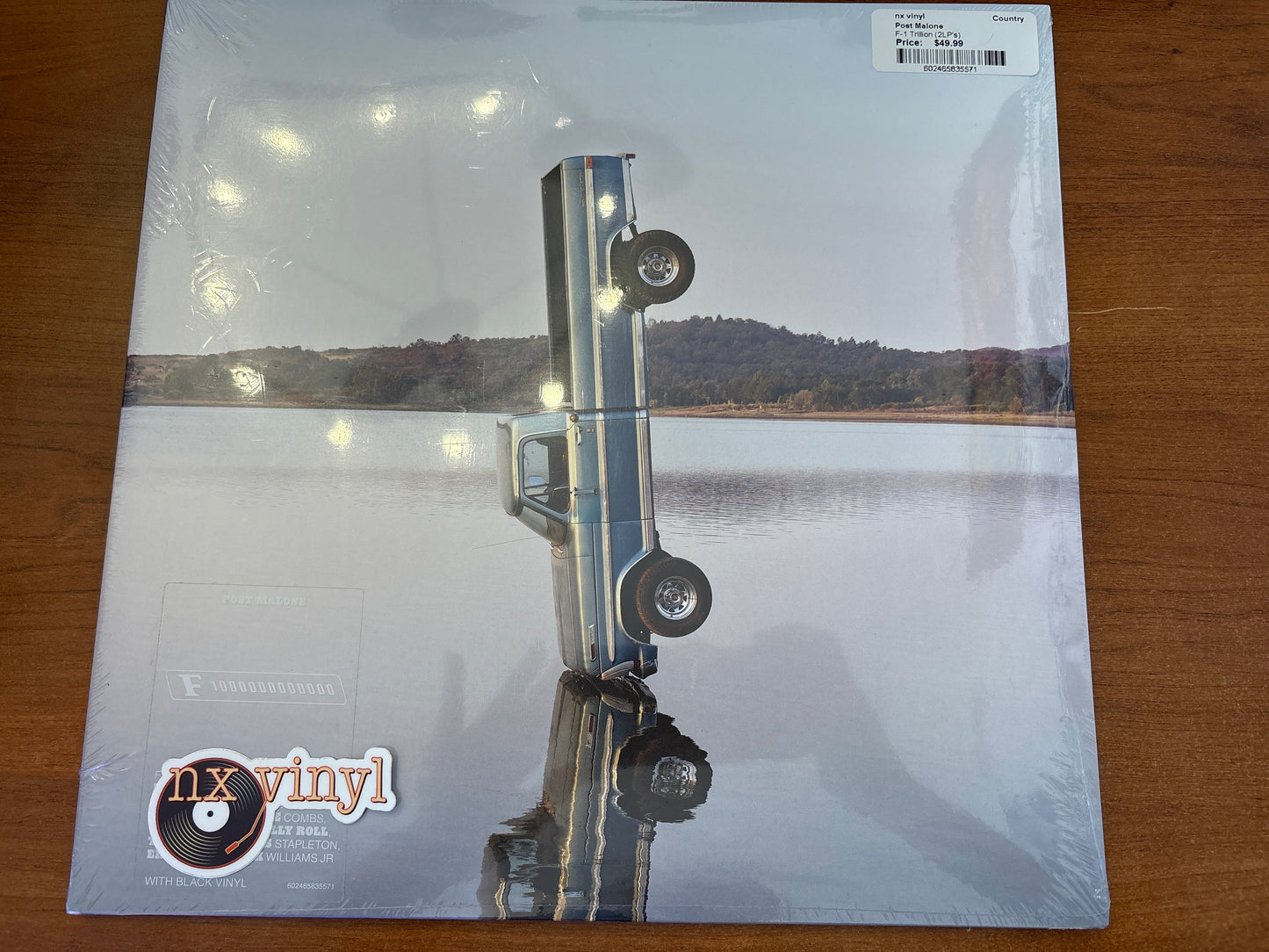 Vinyl record sleeve with a lake and dock scene on a wooden surface