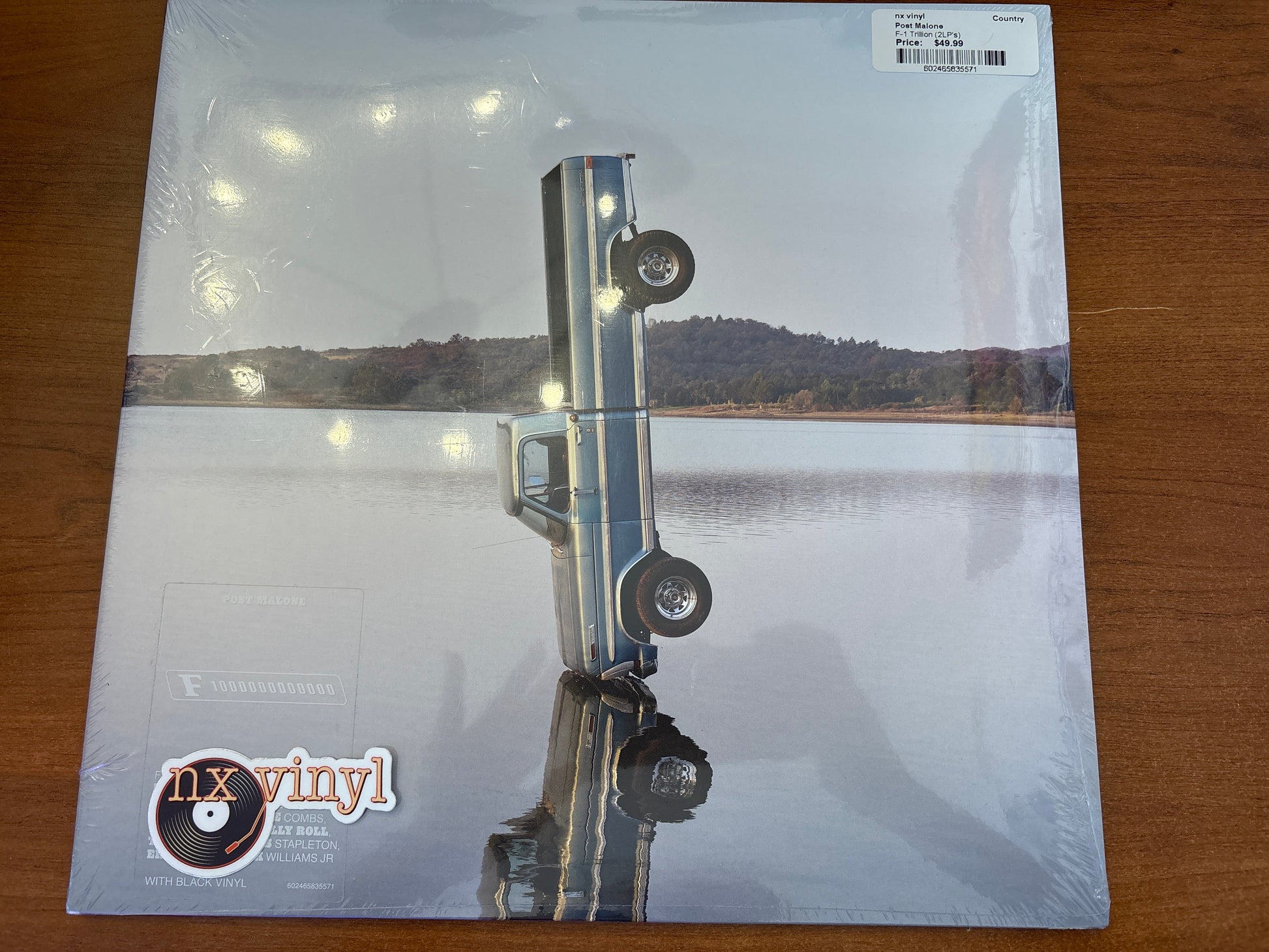 Vinyl record sleeve with a lake and dock scene on a wooden surface