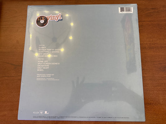 Back cover of a vinyl record with 'nx vinyl' branding on a wooden surface