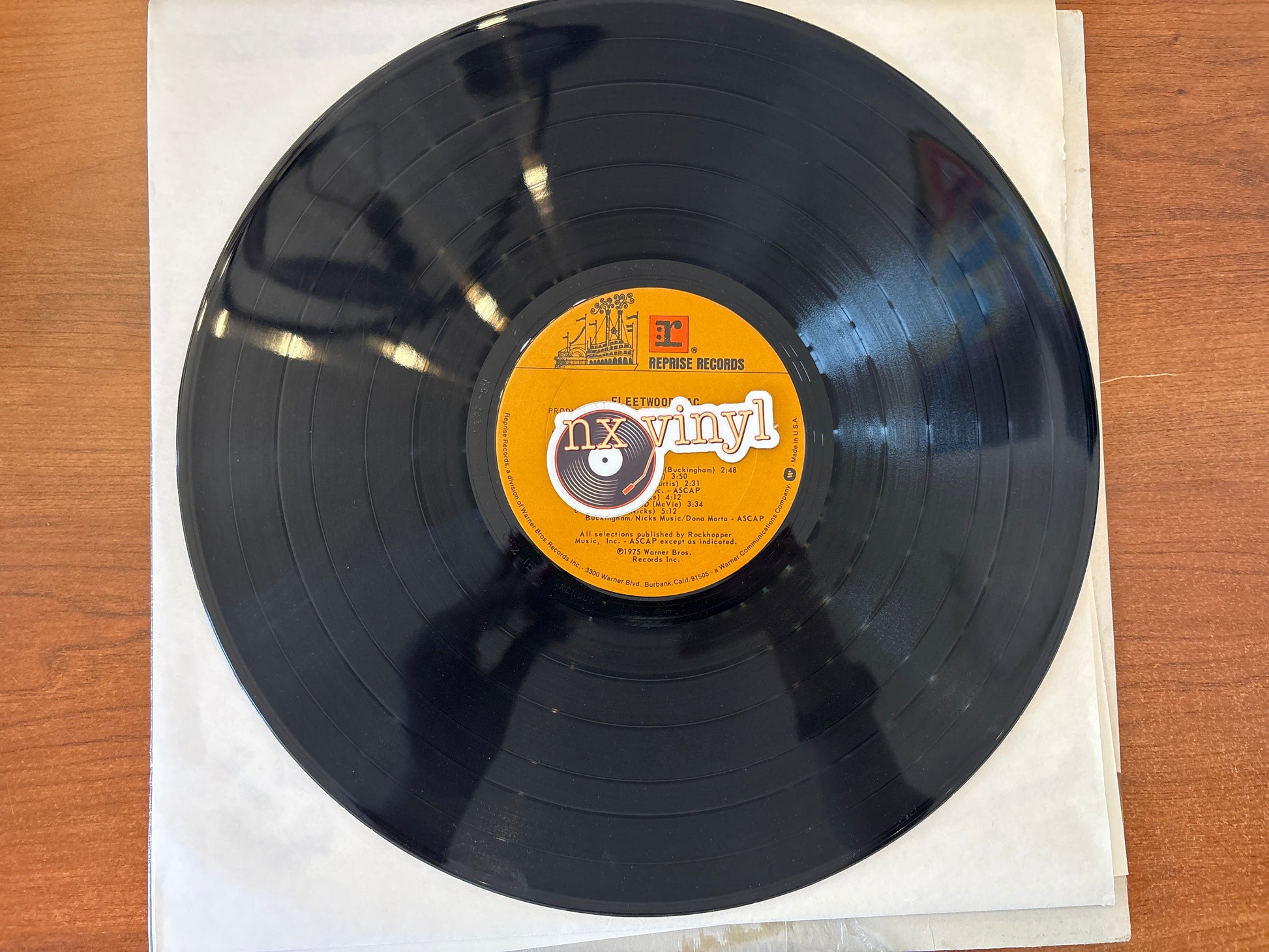 Vinyl record with a label on a wooden surface