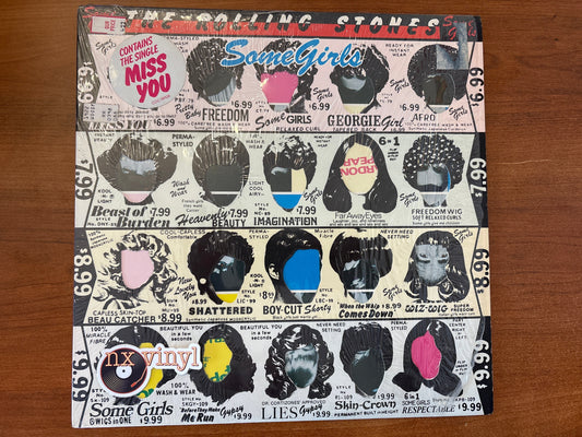 Vinyl record cover with 'The Rolling Stones' and 'Some Girls' album title on a wooden surface
