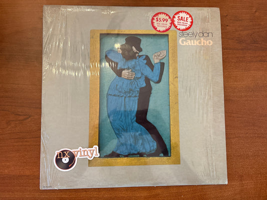 Vinyl record cover with illustration of two people dancing, on a wooden surface.
