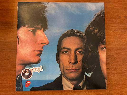 Album cover with three faces against a blue sky, featuring 'n' vinyl and The Rolling Stones logos.