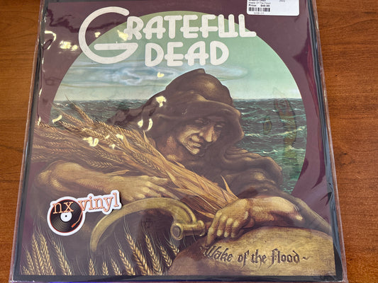 Vinyl record cover for 'Lake of the Flood' by Grateful Dead on a wooden surface.
