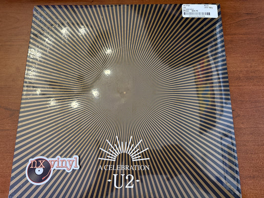 Vinyl record with U2 branding on a wooden surface