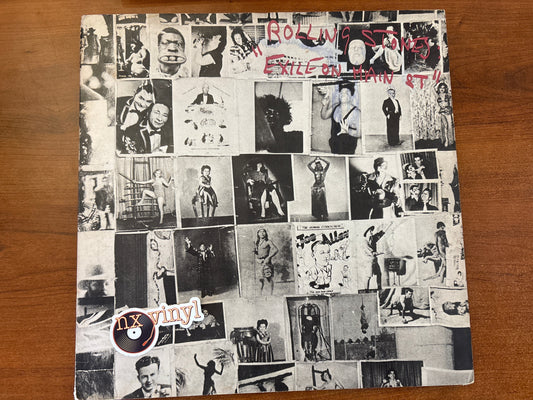 Vinyl record cover with black and white collage of images on a wooden surface