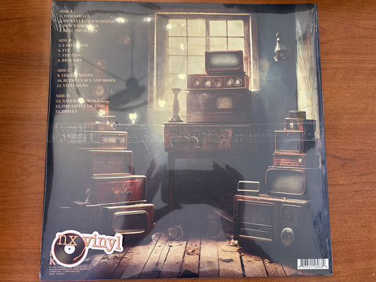 Vinyl record sleeve with vintage radio and record player design on a wooden surface