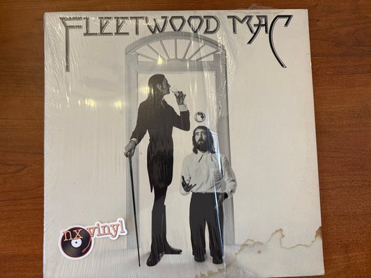 Fleetwood Mac album cover with two figures in front of a door on a wooden surface